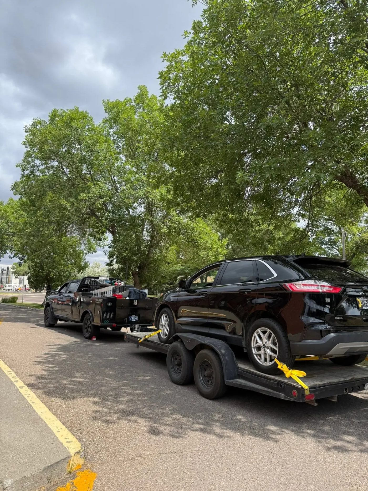 Vehicle loaded and strapped on the 406 Mobile Mechanic trailer behind the work truck