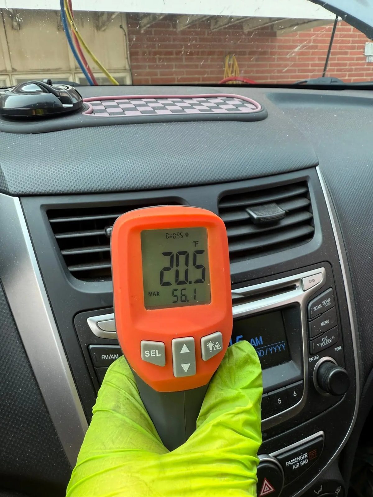 Infrared thermometer showing a 20.5°F vent temperature after an AC repair